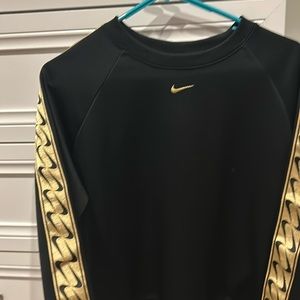 Size Xs fits small and medium Black and gold nike sweatshirt